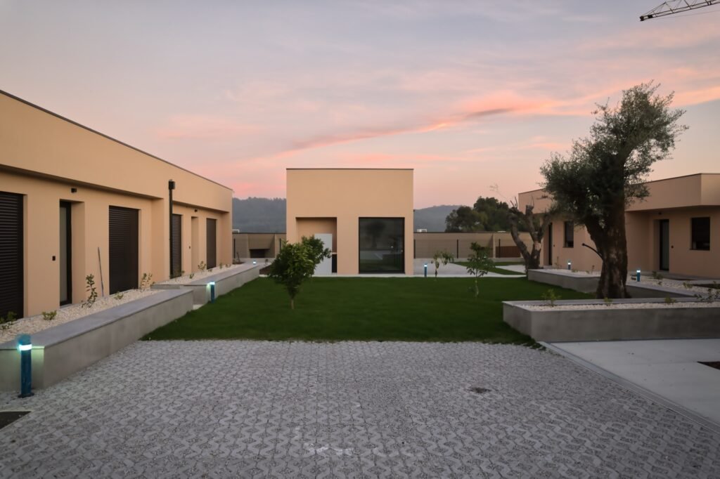 Jardim central com relvado e floreiras