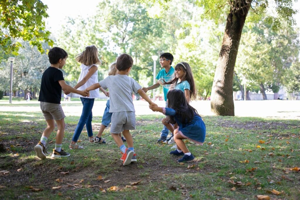 Crianças a brincar de roda no parque