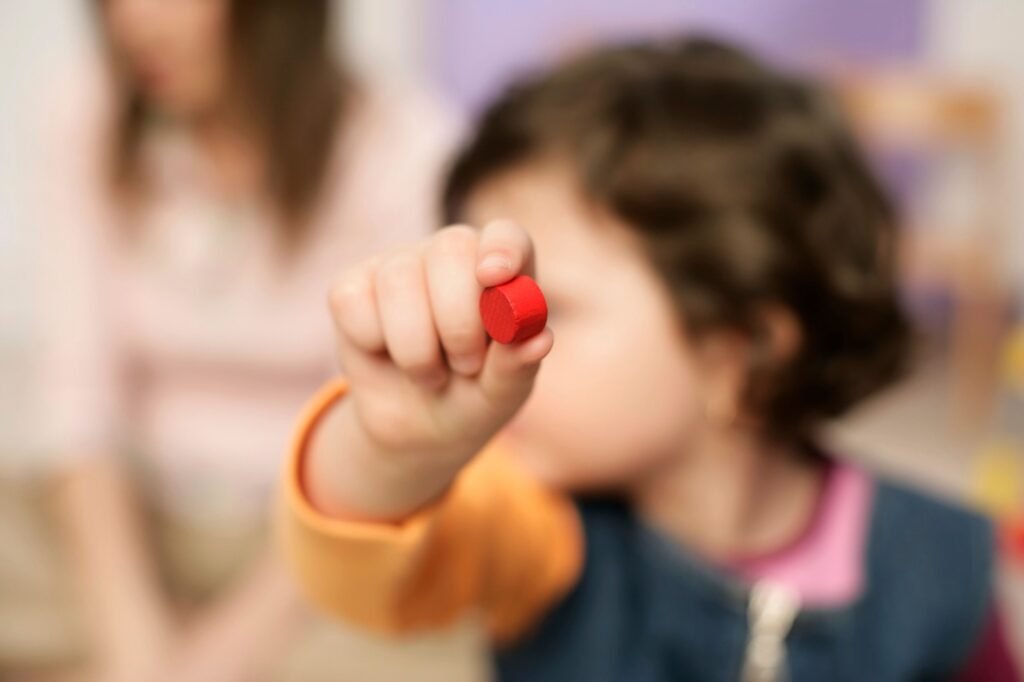 Criança pequena a brincar com um cubo de madeira
