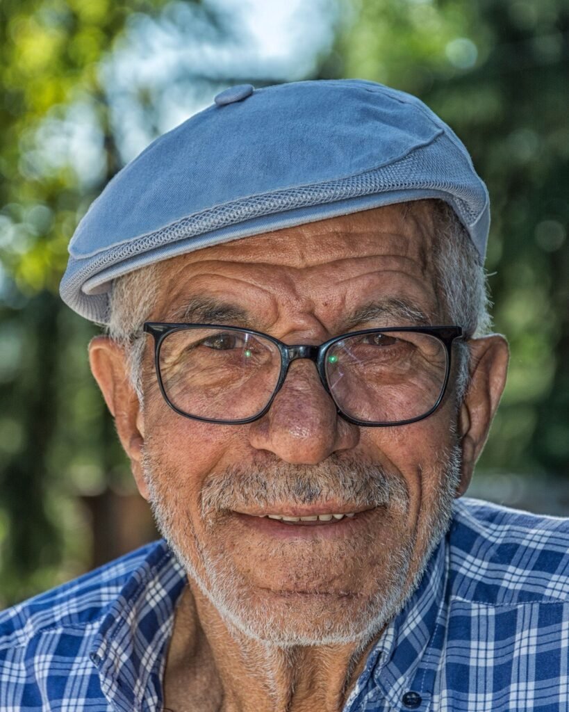 Senhor idoso sorridente de boné e óculos